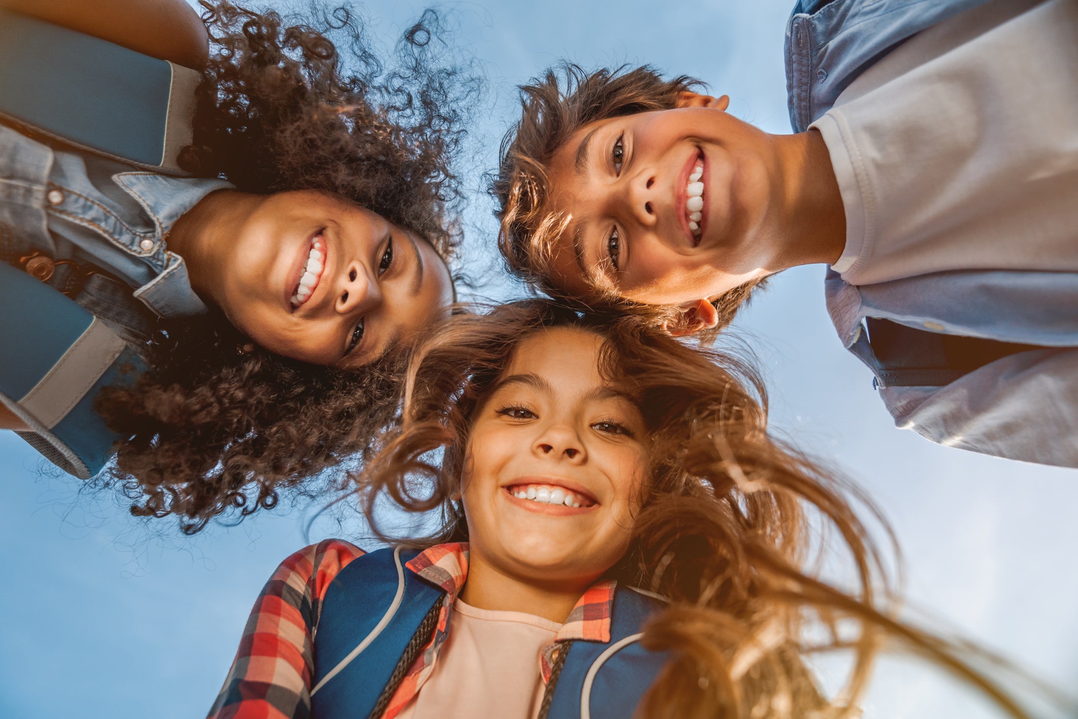 Portrait of smiling school kids standing in circle at school yard  looking in camera