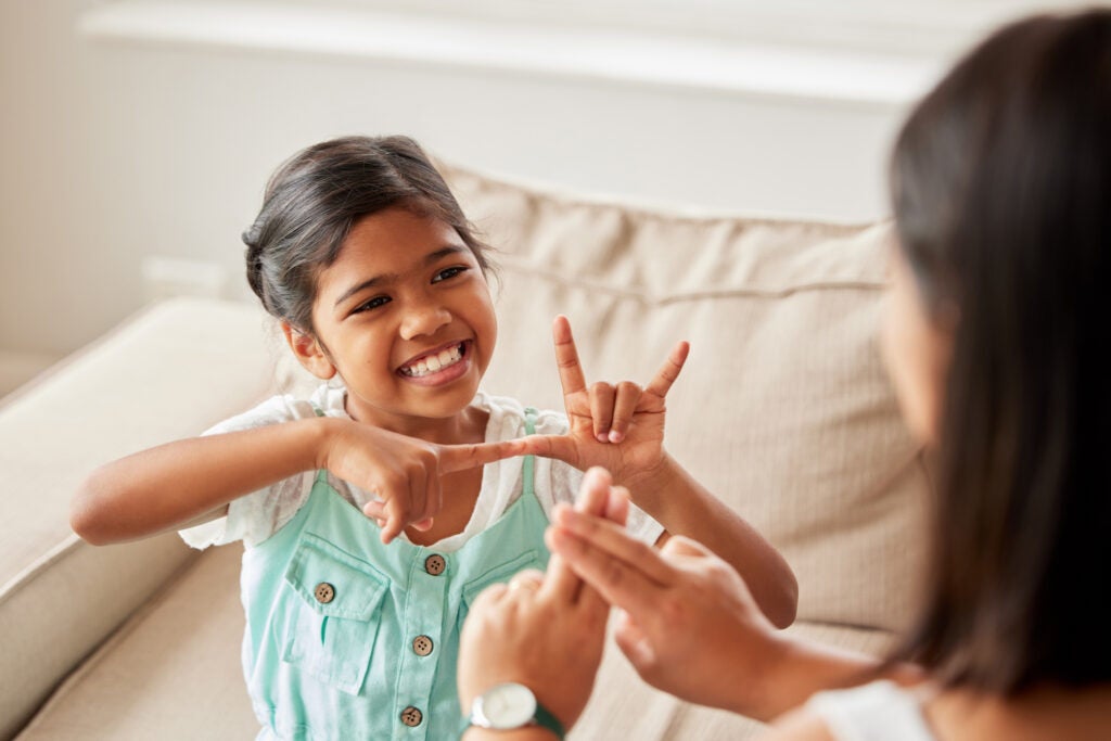 Deaf Indian girl and mother communicating using sign language